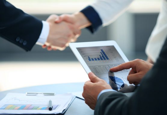 Business associates shaking hands in office